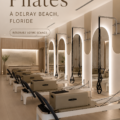 Une femme pratiquant le Pilates dans un studio bien éclairé, entourée de matériel de fitness.